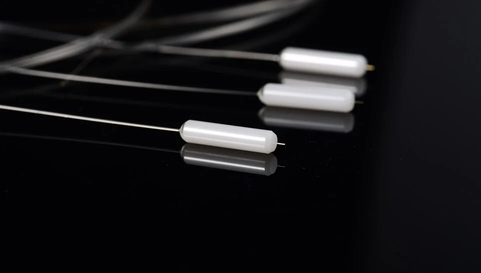 Cola de fibra con punta sobresaliente y recubrimiento AR